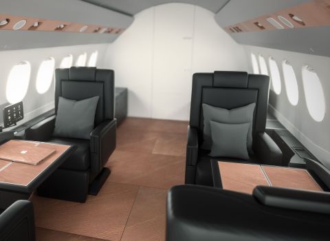 Private Jet Interieur mit Natursteinfurnier Luxuriöser Flugzeug-Innenraum mit schwarzen Ledersesseln und Tischen aus leichtem Natursteinfurnier in warmem Braunton.